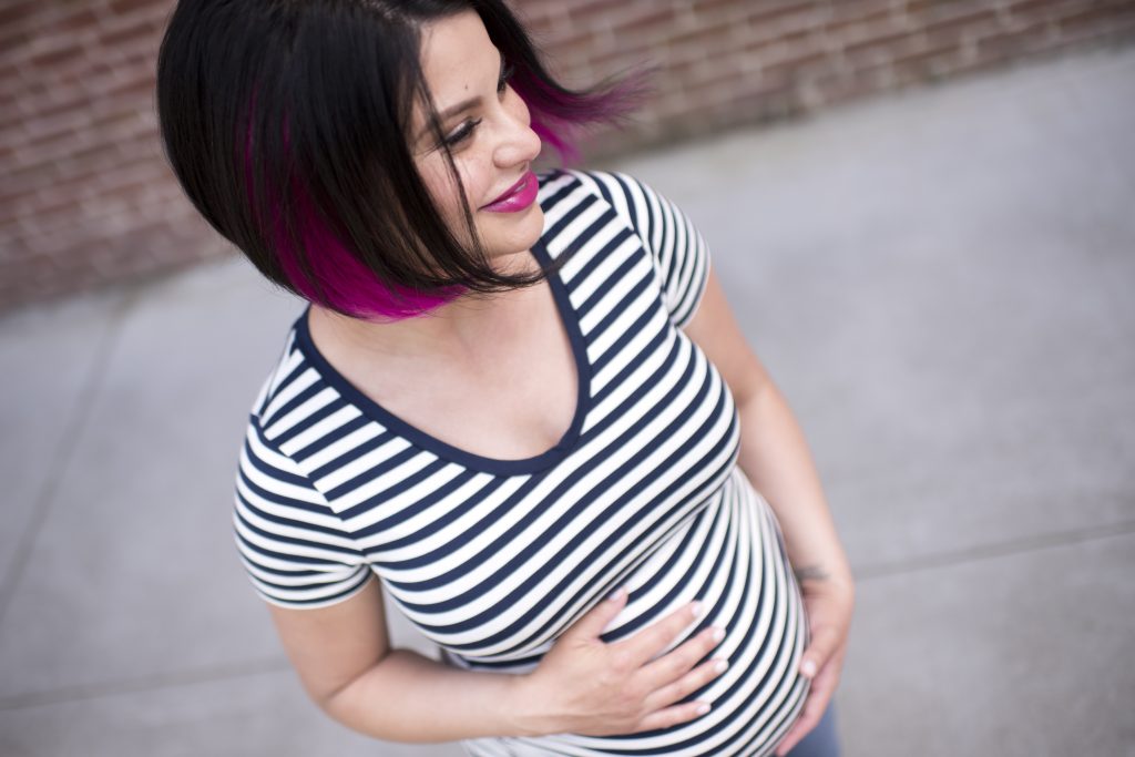 rosanne pregnant wearing white with black pinstripes t-shirt